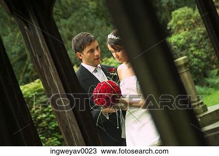 A newly married couple talking in a garden View Large Photo Image Stock Image - A newly married couple talking in a garden. Fotosearch