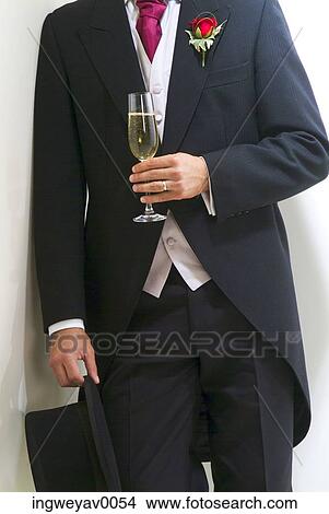 Close-up of a groom holding a glass of champagne View Large Photo Image Picture - Close-up of a groom holding a glass of champagne. Fotosearch