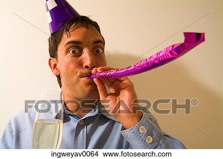 Close-up of a man blowing a party favor View Large Photo Image Picture - Close-up of a man blowing a party favor. Fotosearch