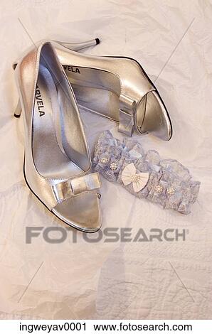 Stock Image - Close-up of a pair of high heel lady's shoes and a garter belt. Fotosearch