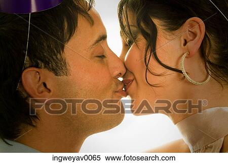 Close-up of a young couple kissing each other View Large Photo Image Stock Photography - Close-up of a young couple kissing each other. Fotosearch