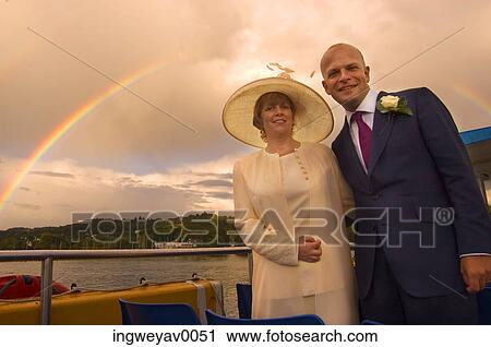 Portrait of a mid adult couple standing under a rainbow View Large Photo Image Stock Image - Portrait of a mid adult couple standing under a rainbow. Fotosearch