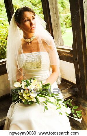 Stock Image - Portrait of a young bride holding a bouquet of flowers. Fotosearch