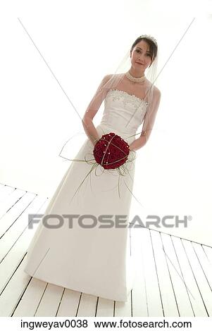 Portrait of a young bride holding a bouquet of roses View Large Photo Image Stock Photo - Portrait of a young bride holding a bouquet of roses. Fotosearch
