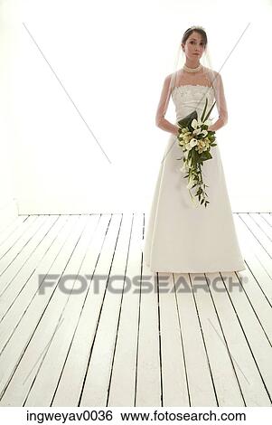 Portrait of a young bride holding a bouquet of flowers View Large Photo Image Stock Photograph - Portrait of a young bride holding a bouquet of flowers. Fotosearch