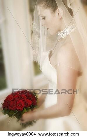 Side profile of a young bride holding a bouquet of roses View Large Photo Image Picture - Side profile of a young bride holding a bouquet of roses. Fotosearch