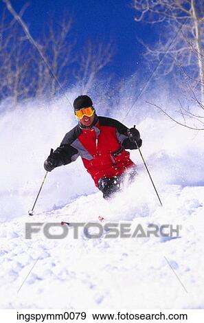 A male skier skiing down a slope View Large Photo Image Stock Photo - A male skier skiing down a slope. Fotosearch
