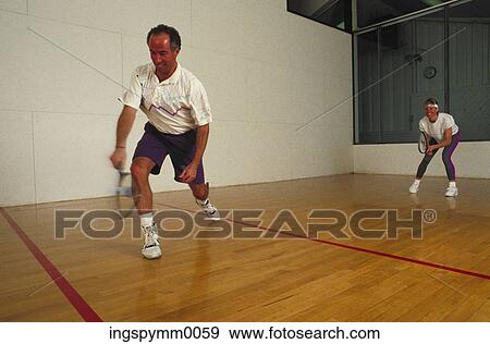 A mid adult man and woman playing indoor squash View Large Photo Image Stock Photo - A mid adult man and woman playing indoor squash. Fotosearch