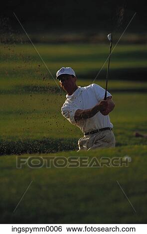 Stock Photograph - A mid adult man playing golf. Fotosearch
