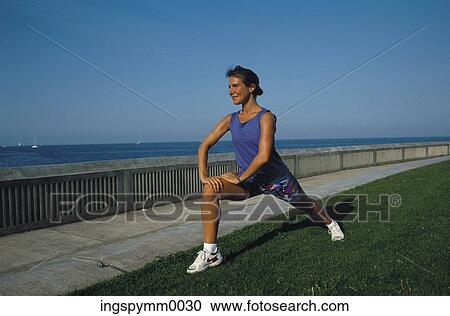Stock Image - A woman stretching at the sea front. Fotosearch