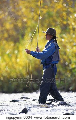 A young woman holding a fishing rod standing in a lake View Large Photo Image Picture - A young woman holding a fishing rod standing in a lake. Fotosearch