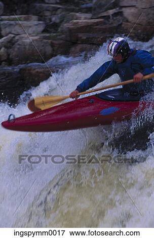 Stock Photo - Close-up of a man canoeing in white water rapids. Fotosearch