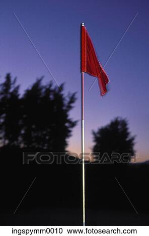 Stock Image - Close-up of a red flag on a golf course. Fotosearch