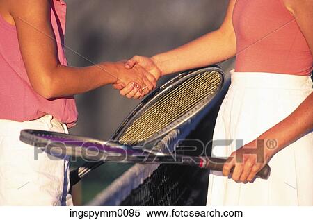 Close-up of two women shaking hands over a net on a tennis court View Large Photo Image Stock Photography - Close-up of two women shaking hands over a net on a tennis court. Fotosearch