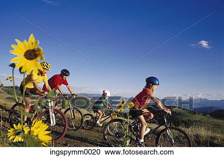 Family cycling on a hilly trail View Large Photo Image Stock Image - Family cycling on a hilly trail. Fotosearch