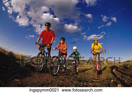 Family cycling on a hilly trail View Large Photo Image Stock Image - Family cycling on a hilly trail. Fotosearch