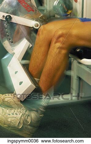 Stock Photograph - Legs of a man working out in a gym. Fotosearch