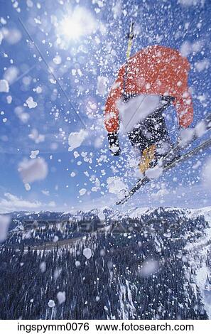Low angle view of a skier throwing up snow while skiing on a mountain View Large Photo Image Stock Photograph - Low angle view of a skier throwing up snow while skiing on a mountain. Fotosearch