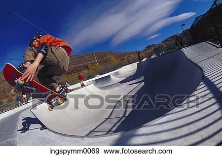 Low angle view of a teenage boy skateboarding on a ramp View Large Photo Image Stock Photo - Low angle view of a teenage boy skateboarding on a ramp. Fotosearch