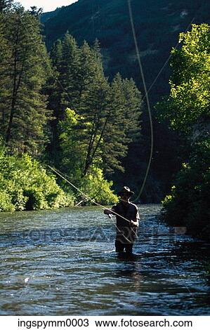 Man fly fishing in a lake View Large Photo Image Stock Image - Man fly fishing in a lake. Fotosearch
