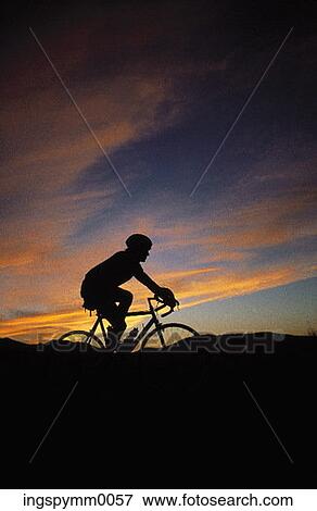 Silhouette of a young biker on a hilly trail View Large Photo Image Stock Photo - Silhouette of a young biker on a hilly trail. Fotosearch