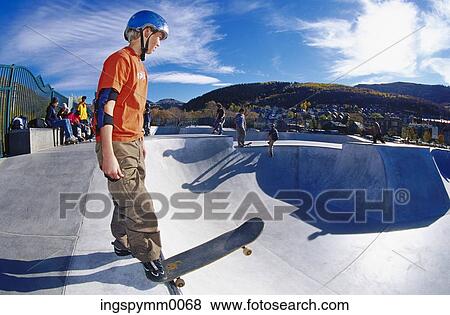 Teenage boy standing with a skateboard on top of a ramp View Large Photo Image Stock Photo - Teenage boy standing with a skateboard on top of a ramp. Fotosearch
