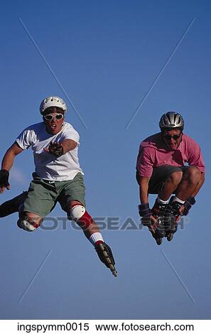 Two young male roller bladders jumping in the air View Large Photo Image Stock Photography - Two young male roller bladders jumping in the air. Fotosearch