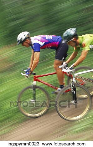 Two young men racing down a hill on bicycles View Large Photo Image Stock Image - Two young men racing down a hill on bicycles. Fotosearch