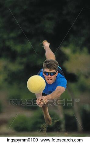 Young man jumping in midair playing volleyball View Large Photo Image Stock Image - Young man jumping in midair playing volleyball. Fotosearch
