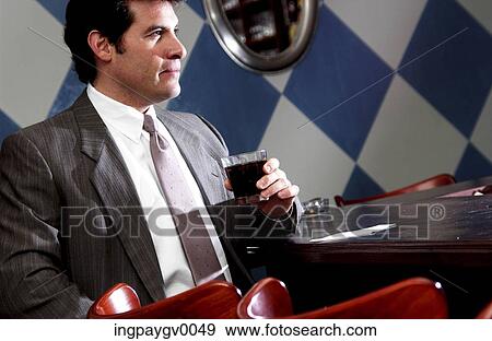Stock Photo - A businessman holding a glass of wine. Fotosearch