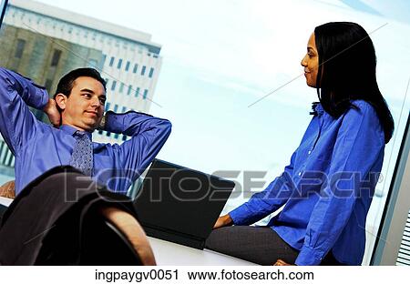 A businessman talking to a young businesswoman in an office View Large Photo Image Stock Image - A businessman talking to a young businesswoman in an office. Fotosearch
