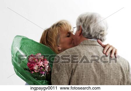 Stock Image - A mature couple kissing each other. Fotosearch