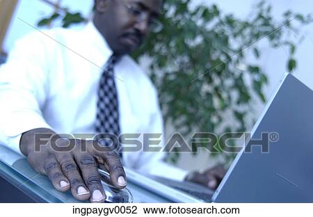 A mid adult businessman working on a laptop computer View Large Photo Image Stock Image - A mid adult businessman working on a laptop computer. Fotosearch