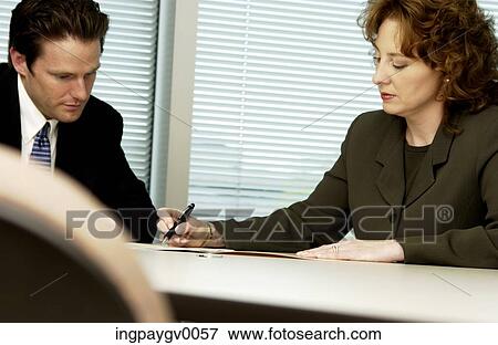 A mid adult businesswoman with a young businessman in an office View Large Photo Image Stock Photo - A mid adult businesswoman with a young businessman in an office. Fotosearch