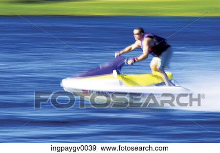 A mid adult man riding a jet ski View Large Photo Image Stock Photo - A mid adult man riding a jet ski. Fotosearch