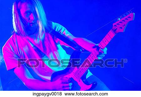 A young man with long hair playing an electric guitar View Large Photo Image Stock Photo - A young man with long hair playing an electric guitar. Fotosearch