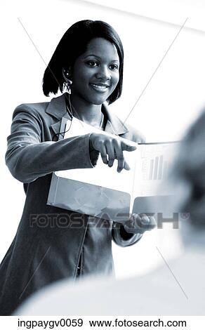 A young woman in a business suit holding a file View Large Photo Image Stock Photo - A young woman in a business suit holding a file. Fotosearch