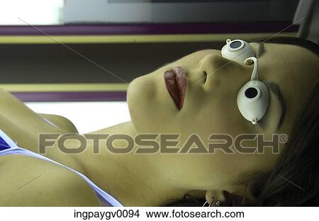 A young woman lying in a tanning capsule View Large Photo Image Picture - A young woman lying in a tanning capsule. Fotosearch