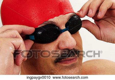Close-up of a male swimmer adjusting his swimming goggles View Large Photo Image Stock Image - Close-up of a male swimmer adjusting his swimming goggles. Fotosearch