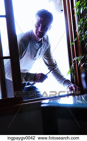 Close-up of a man looking through a window View Large Photo Image Stock Image - Close-up of a man looking through a window. Fotosearch
