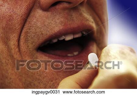 Close-up of a man taking a pill View Large Photo Image Stock Image - Close-up of a man taking a pill. Fotosearch