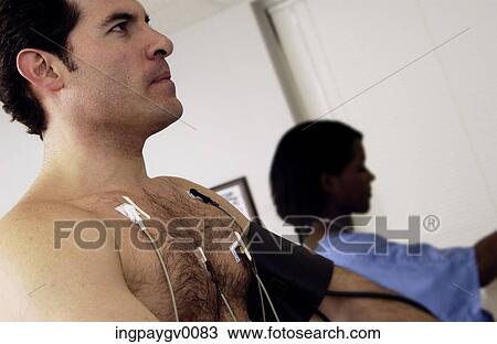 Stock Image - Close-up of a man wearing electrodes for an ECG during a physical fitness test. Fotosearch