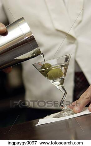 Close-up of a martini being poured from a shaker into a glass with two olives View Large Photo Image Stock Photo - Close-up of a martini being poured from a shaker into a glass with two olives. Fotosearch
