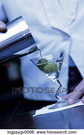 Close-up of a martini being poured from a shaker into a glass with two olives View Large Photo Image Stock Photo - Close-up of a martini being poured from a shaker into a glass with two olives. Fotosearch