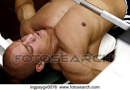 Close-up of a muscled young man lifting bar bells in a gym View Large Photo Image Stock Photograph - Close-up of a muscled young man lifting bar bells in a gym. Fotosearch