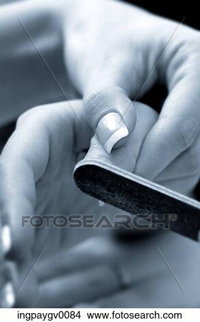 Close-up of a woman filing her nails View Large Photo Image Picture - Close-up of a woman filing her nails. Fotosearch
