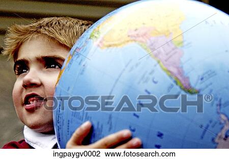 Stock Image - Close-up of a young boy holding a large globe. Fotosearch