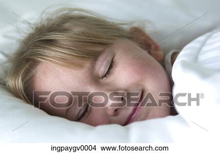 Close-up of a young girl smiling in her sleep View Large Photo Image Picture - Close-up of a young girl smiling in her sleep. Fotosearch