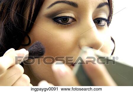 Close-up of a young woman putting on makeup View Large Photo Image Stock Image - Close-up of a young woman putting on makeup. Fotosearch