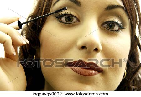 Close-up of a young woman putting on mascara View Large Photo Image Stock Image - Close-up of a young woman putting on mascara. Fotosearch